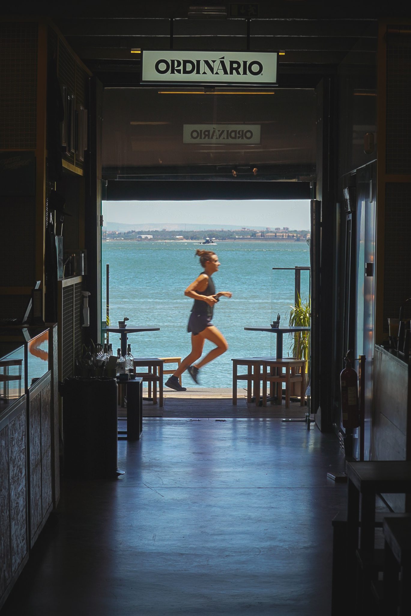 a woman running across a threshold, with a big river as background